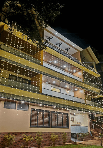 The lodge facade lit up with string lights after dark